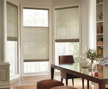 Motorization Dining area with a wooden table, chairs, ottomans, and windows covered by woven bamboo blinds.